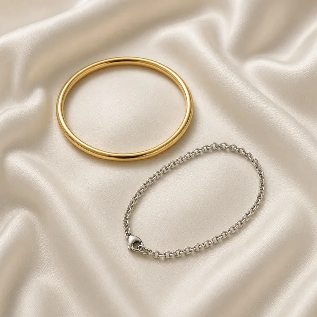 Unbranded gold bangle and silver chain bracelet on silk