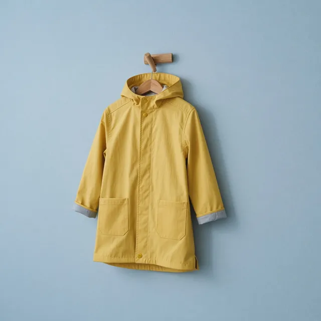 Unbranded yellow kids raincoat on a wooden peg