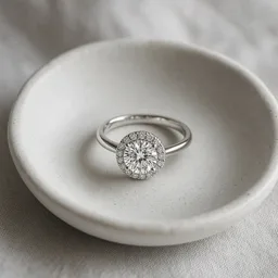 Unbranded halo diamond ring in a small white dish